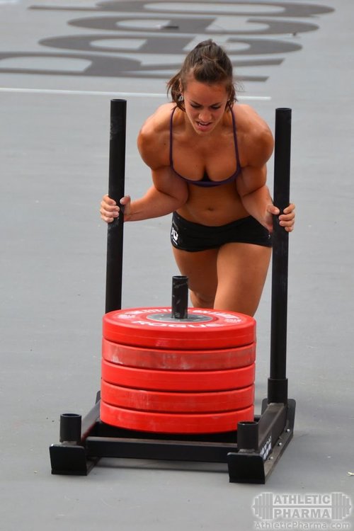 Спортсменка талкает сани (кроссфит)