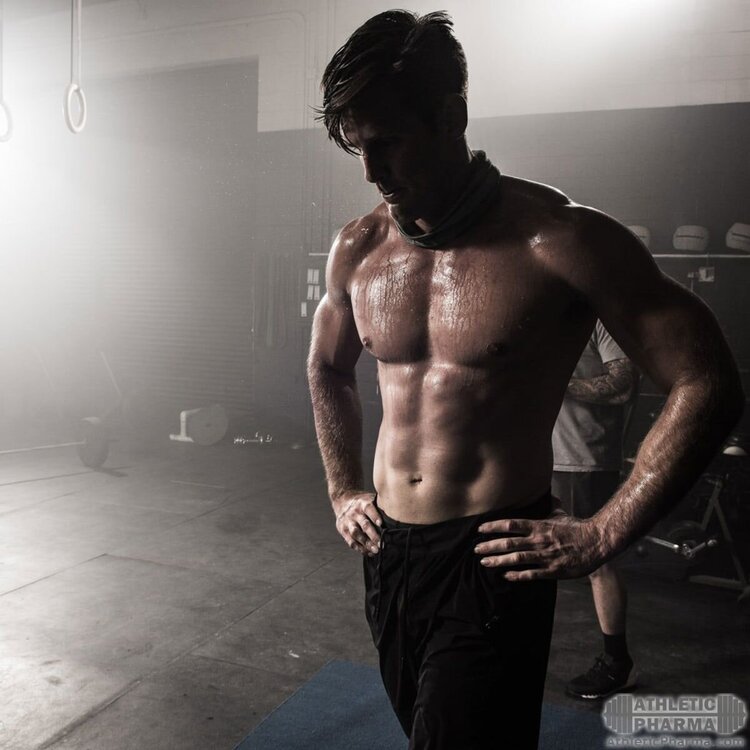 Парень после тяжелой тренировки в спортзале