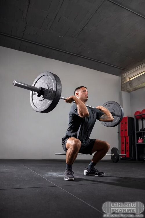 Поднимает штангу на грудь